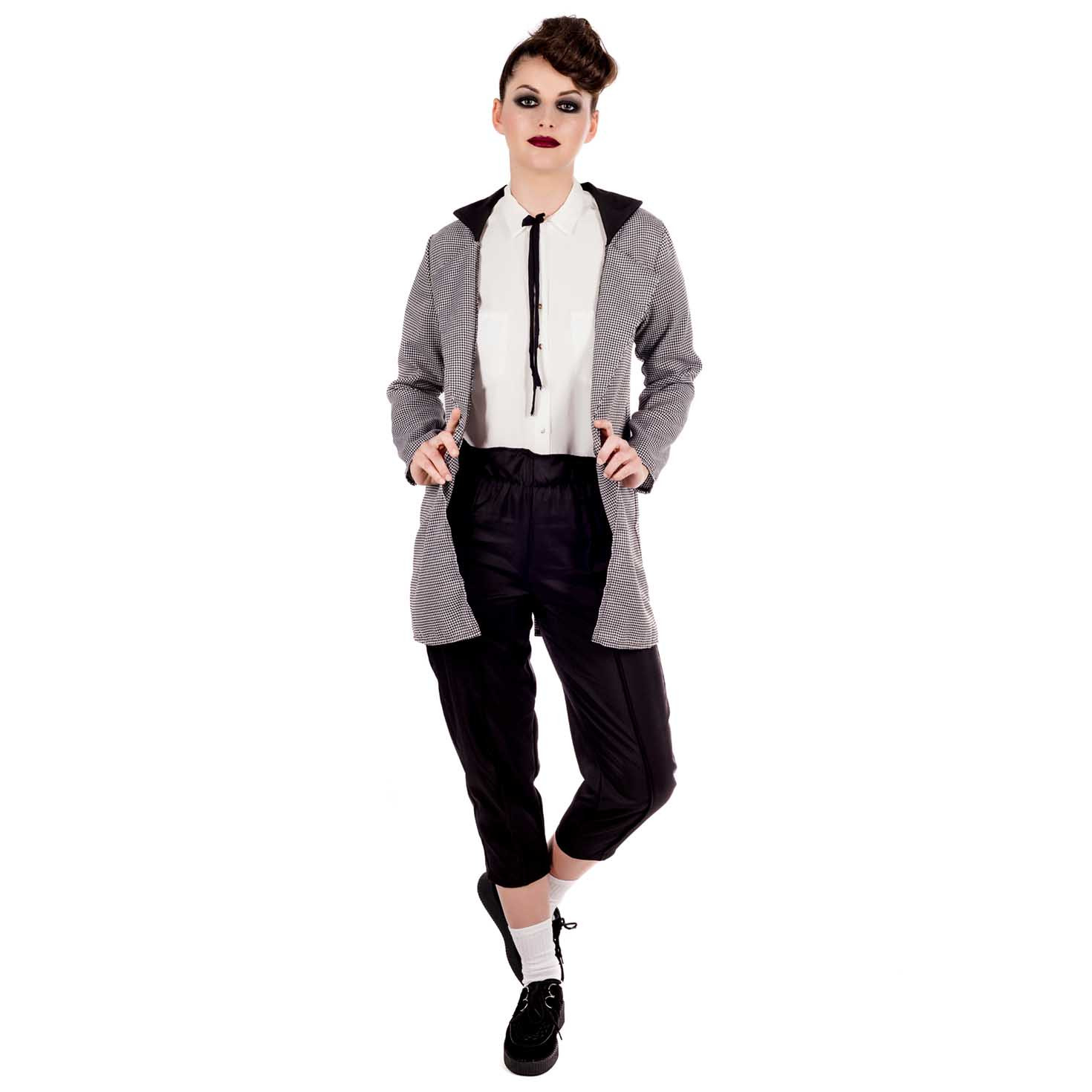 A woman in a check 1950s teddy girl jacket, trousers and skinny tie